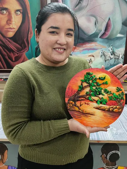 A student displaying her beautiful Shilpkar clay art, which depicts a serene landscape. This versatile clay can be used to create a wide variety of 3D artworks.