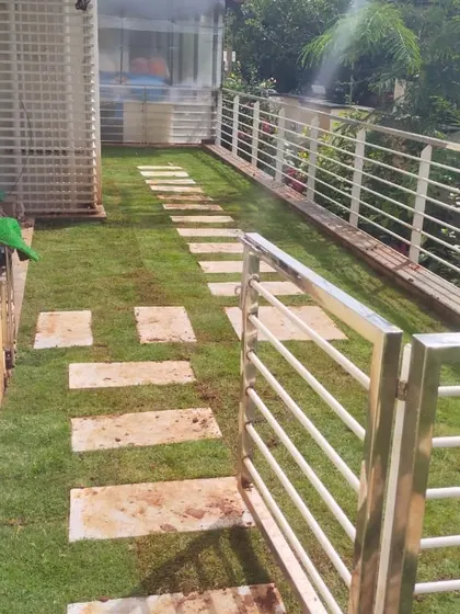 A finished side yard path with stone steppers set into a new lawn, leading to a stainless steel gate. This is a clean and modern approach to combining hardscaping and softscaping.