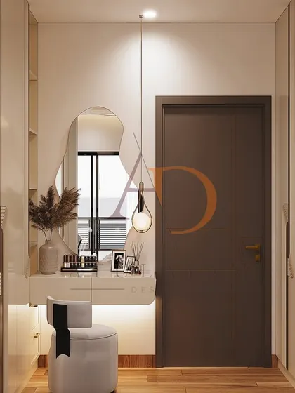 An elegant dressing area within the bedroom, featuring a floating vanity with a backlit, organically shaped mirror and a stylish pendant light.