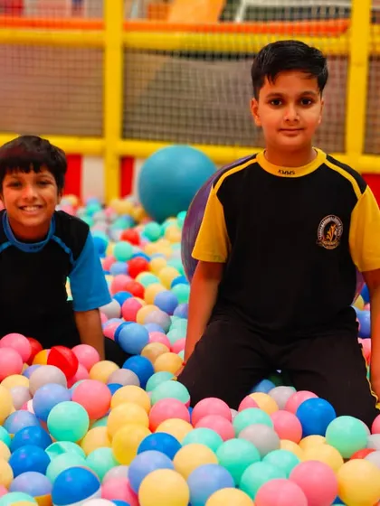 Two friends enjoying the ball pit. It’s a perfect spot for younger kids to play safely and have a blast during their school outing.