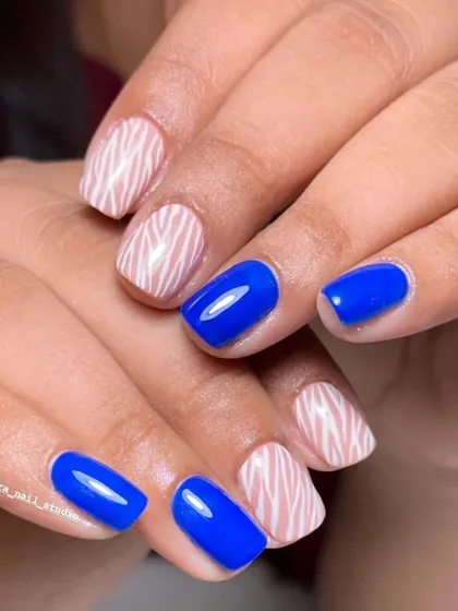 A full set of the bold blue and zebra stripe nails. This shows how to balance a solid color with a pattern for a look that is eye-catching but not overwhelming.