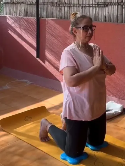 A member in a kneeling prayer pose during a yoga session. We provide props and modifications to make every pose accessible, no matter your flexibility.