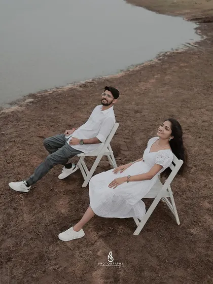 A duplicate of 295, showing a minimalist and artistic shot of the couple relaxing in chairs by the lakeside on an overcast day.