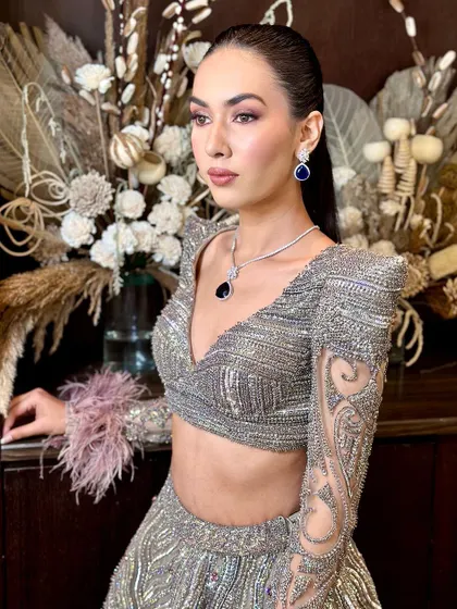 A high-fashion, luxury glam look for a cocktail party. The makeup is sharp and defined, with a sleek hairstyle and a focus on structure.
