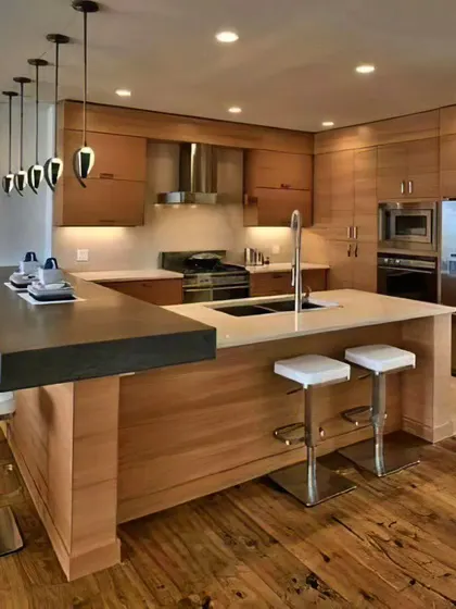 This large, U-shaped island in a natural wood finish offers extensive counter space and a multi-level breakfast bar. It's the ultimate centerpiece for a spacious, open-plan home.