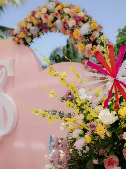 A custom heart-shaped backdrop with the couple's initials, adorned with a lush arch of pastel flowers.