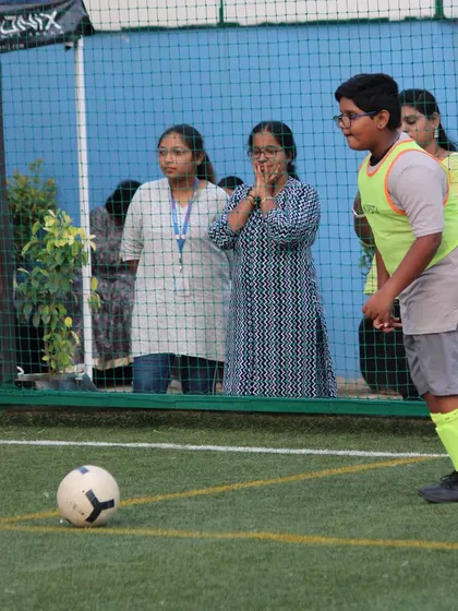 With family watching anxiously from the sidelines, a player prepares to take a crucial kick during a tournament game.