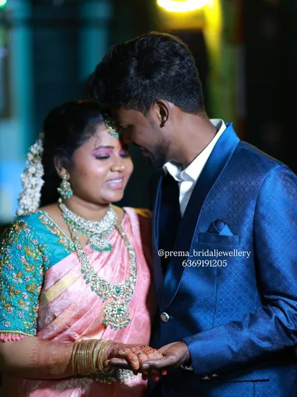 A romantic photo of the couple at their reception. The bride's glamorous makeup and jewellery look stunning against the groom's sharp blue suit.
