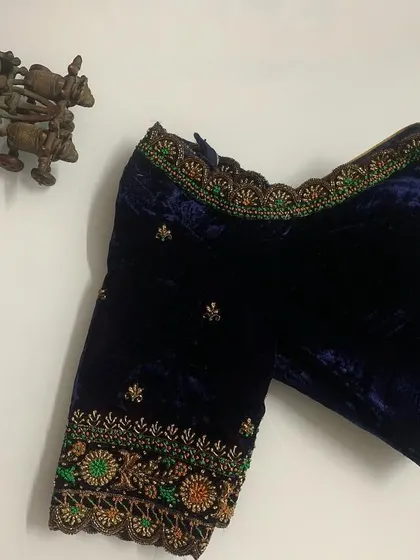 Another view of the navy velvet blouse, showing the intricate detail of the floral embroidery along the sleeve border.