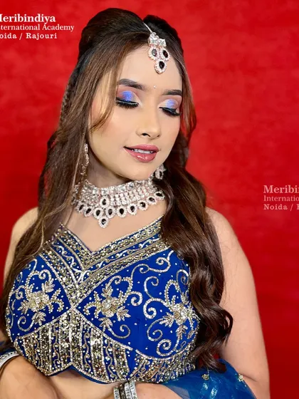A glamorous engagement hairstyle with a half-up, half-down look, featuring a bouffant for volume and a maang tikka.