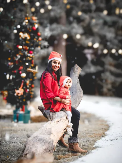 A magical, AI-enhanced Christmas portrait. We photographed this mother and daughter in our studio and then placed them in a dreamy, snowy forest with a decorated tree.
