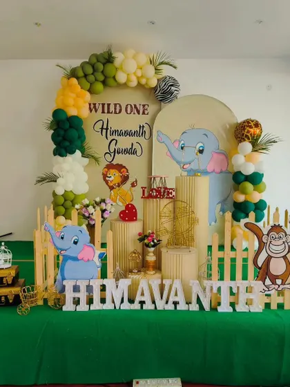 A "Wild One" jungle theme is one of our specialties. This setup for Himavanth's first birthday features cute animal cutouts, a lush green color palette, and a custom backdrop for a fun-filled celebration.