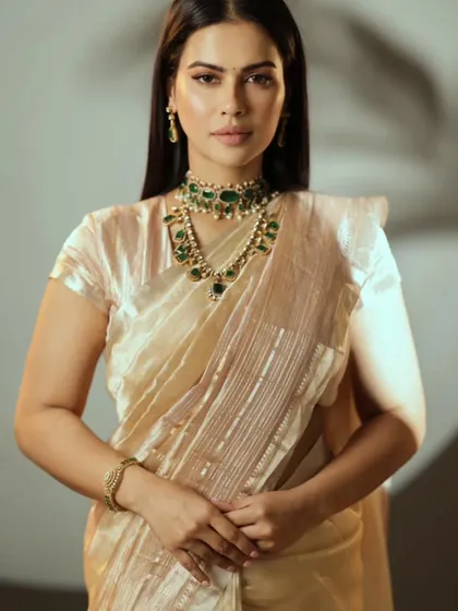Actress Dhanya Ramkumar wearing a simple yet elegant custom-stitched golden blouse with a matching tissue saree.