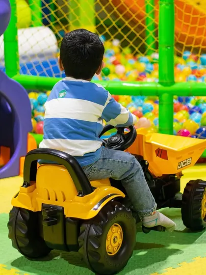 Little builders at work! Our ride-on tractor is perfect for kids who love construction, letting them cruise around the play area with a backdrop of our colorful ball pit.