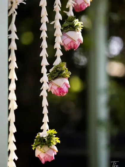 We use fresh, fragrant flowers in our decor. These delicate hangings are made of jasmine buds and pink lotus, adding a touch of grace and tradition to the event space.