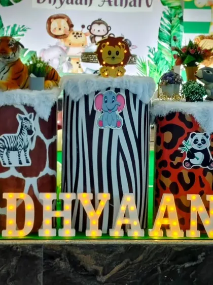 A close-up of the animal-print pedestals and light-up name from a jungle themed party.