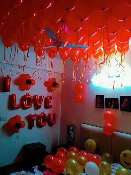 A room filled with red balloons and an 'I LOVE YOU' foil letter sign. This is a classic and powerful way to express your feelings on a special day.
