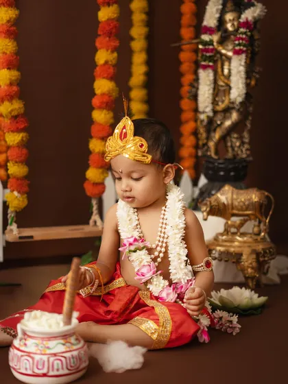 A quiet, contemplative moment of a little boy dressed as Krishna during his photoshoot.