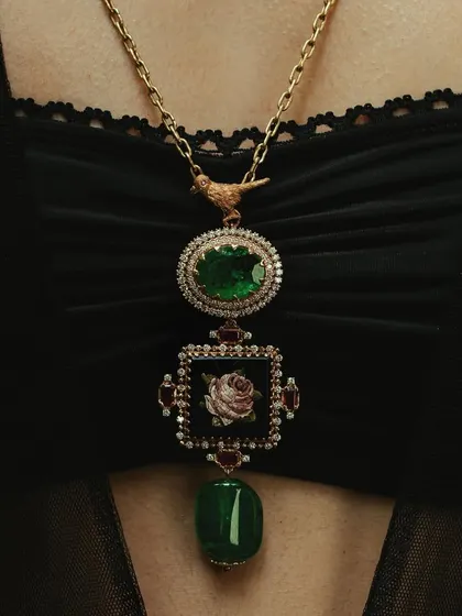 A close up of the micromosaic classic rose pendant worn by Shilpa Shetty. This piece combines a micromosaic rose with Zambian emeralds, creating a unique and timeless necklace.