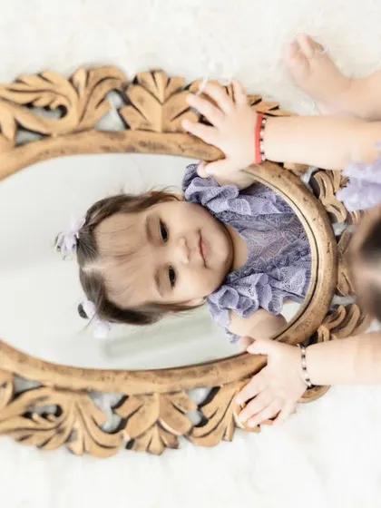 A creative top-down shot of the birthday girl with her reflection. We love finding unique angles to create artistic and memorable birthday photos.