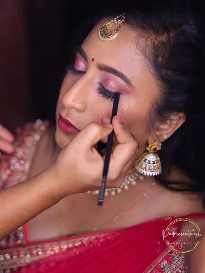 A behind the scenes look at the eye makeup process. Here, I am applying eyeliner with precision to define the eyes, a crucial step for a glamorous reception look.