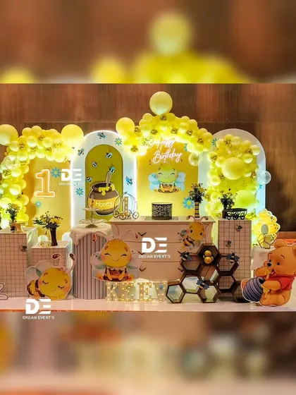 A bright and sunny honeybee and Winnie the Pooh theme for Keev's first birthday. The yellow and white decor includes honeycomb patterns and cute bee characters.