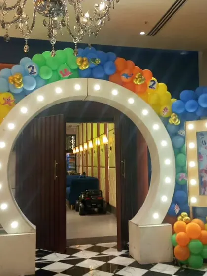 This lit-up circular arch makes for a fantastic entrance and photo opportunity. We surrounded it with a colorful sea-themed balloon garland and a personalized light-up photo frame for a kid's party, and can customize this design for any wedding theme.