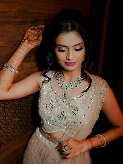 A stunning portrait of the bride-to-be, highlighting her beautiful makeup and the intricate details of her emerald necklace.