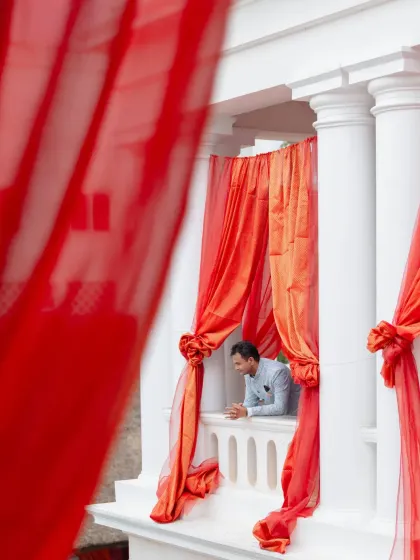 Sometimes, the most powerful moments are the most intimate. Framed by hanging garlands of red and white flowers, this emotional exchange between the couple captures the pure essence of their wedding day promises.