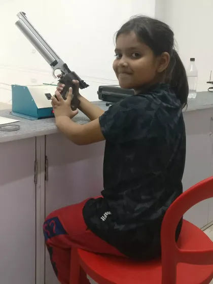 A proud smile from nine year old Koushiki Chauhan at our Gurgaon branch. She is holding a competition grade air pistol, the same type used in the Olympics.