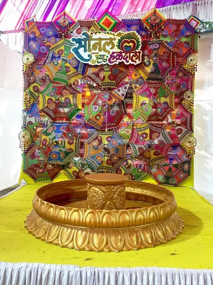 Personalization is key. For this Haldi, we created a custom sign in Marathi that reads 'Sonal cha Haldi Sohala' and placed it on a colorful backdrop made of decorative umbrellas, making the bride feel extra special.