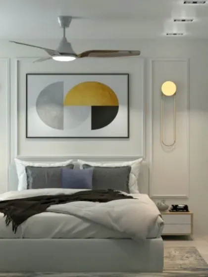 A bright, modern bedroom with gold accents, a geometric art piece, and a window-side dressing table.