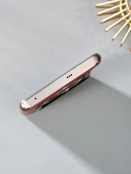 An angled shot showing the bottom of the Realme 12 Pro+, including the speaker grille and charging port, captured with clean lighting.