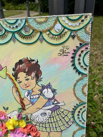 A detail shot of the girl's face and the mirror work on the border of the wall art.