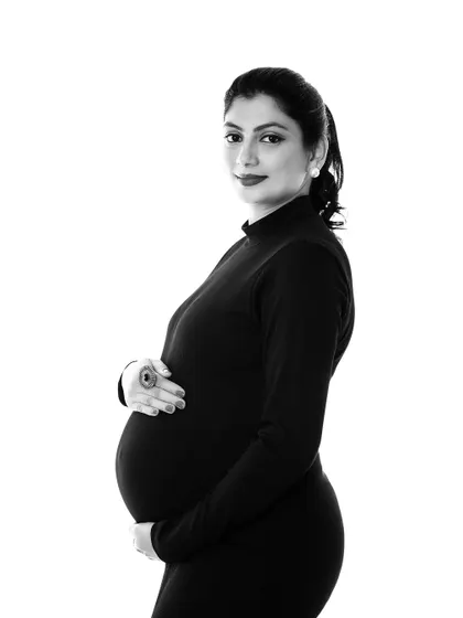 A classic black and white portrait that exudes timeless elegance. The simple high-neck black dress creates a beautiful, clean silhouette.