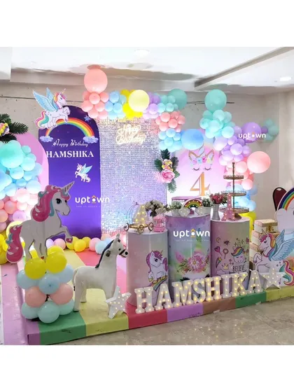 A unicorn-themed 4th birthday party with a sequin backdrop and character cutouts.