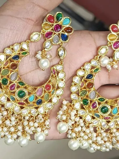 These Navratan style chandbali earrings are full of life and color. The combination of multiple semi-precious stones and pearl drops makes them a versatile choice that can be paired with many different festive outfits.