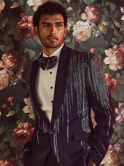We redefine formal wear with this modern tuxedo, featuring a shawl lapel embellished with a cascade of kut-dana work for a touch of sophisticated glamour.