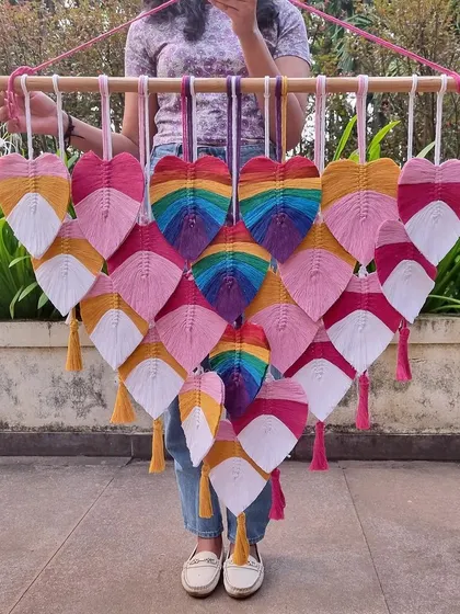 Bringing a burst of boho vibes with these multicolored macrame leaves. This piece, featuring rainbow hearts, is a cheerful and artistic addition to any living room.