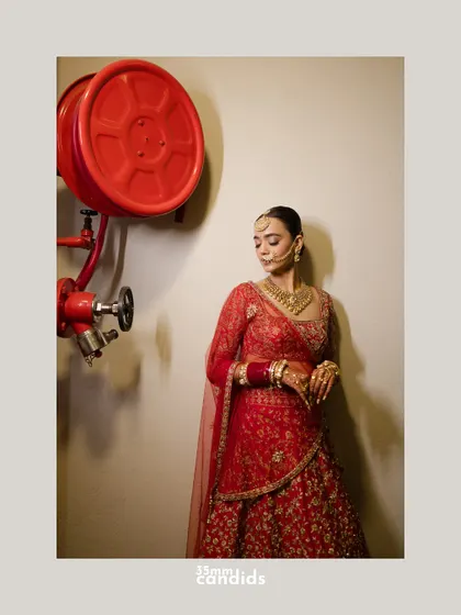 A unique and artistic bridal portrait, juxtaposing the bride's traditional elegance with an industrial fire hose reel. It's about finding beauty in unexpected places.
