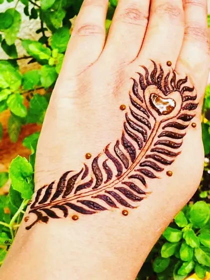 A simple yet striking peacock feather design on the back of the hand. It's a quick and beautiful piece of art for anyone who loves this classic motif.