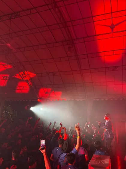 Another angle of the crowd lost in the music under the red lights. The atmosphere was electric.