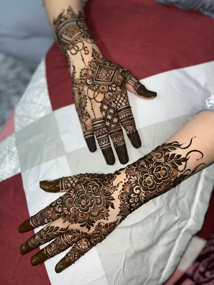 A beautiful pairing of two different styles: one hand with a geometric design and the other with a dense floral pattern.
