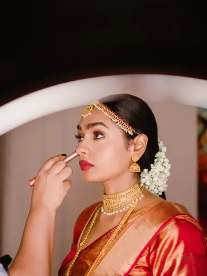 A beautiful behind-the-scenes shot of the South Indian bride getting her makeup done, framed by a ring light. This modern take on a traditional moment is both artistic and intimate.