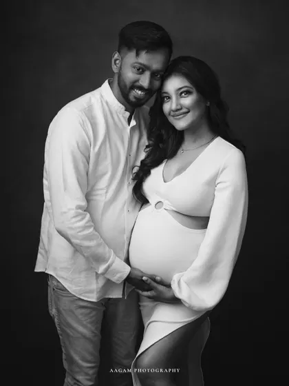 A modern and stylish maternity portrait in black and white. The couple's happy expression and chic outfits are given a timeless feel in monochrome.
