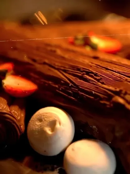 A close-up of a festive dessert from a Christmas event, featuring a chocolate yule log and meringue mushrooms.