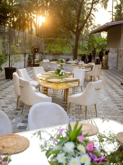 Golden hour at a beautiful outdoor birthday celebration. We used elegant mirrored tables with gold accents and plush velvet chairs to create a luxurious dining experience in a natural, serene setting.