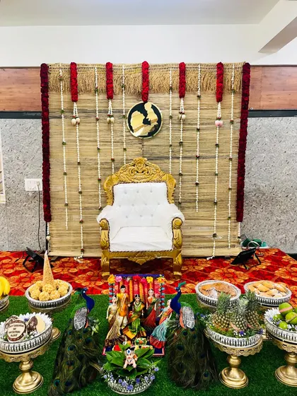 I love creating rustic and earthy themes like this one for a baby shower. The backdrop is made from natural woven mats, decorated with jasmine and red flower garlands, perfectly framing the seer plates which feature peacock motifs and a variety of traditional offerings.