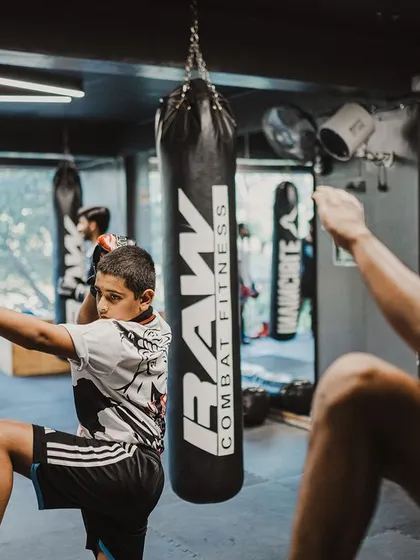 I mirror my student's movements during a Wai Kru practice session. This shows him the correct form and reinforces the deep respect we have for the traditions of Muay Thai.