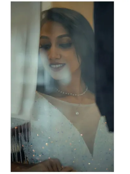A dreamy, through-the-window shot that captures the elegance of the white sequin gown, perfect for a creative photoshoot.